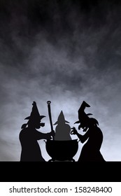 Three witches gathering to brew magic potion in a cauldron on Halloween night. 