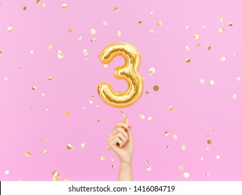 Three year birthday. Female hand holding Number 3 foil balloon. Tree-year anniversary background. 3d rendering