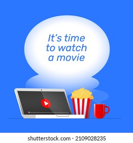 It's Time To Watch A Movie Online. A Laptop With A Video Play Button On A Screen Near Popcorn And Hot Tea In A Cup Is Standing On A Table. Red And Blue Square Composition With A Text.