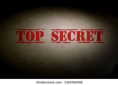 Top secret text on a brown envelope with a light spot.
