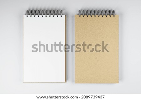 Top view and close up of two white and brown spring notepads on white desktop background. Mock up place for your advertisement. Education, work, supplies and stationery concept. 3D Rendering