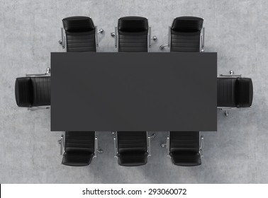 Top view of a conference room. A black rectangular table and eight black leather chairs around. 3D rendering