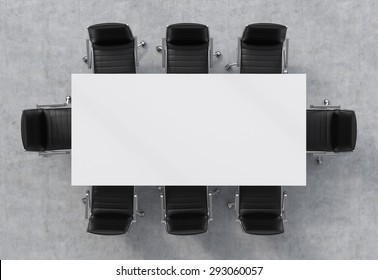 Top view of a conference room. A white rectangular table and eight black leather chairs around. 3D rendering