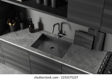 Top View Of Dark Kitchen Interior With Sink And Modern Kitchenware On Deck, Wooden Shelves. Cooking Area In Apartment With Grey Concrete Floor. 3D Rendering