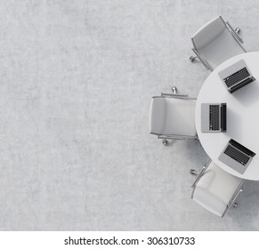 Top view of a half of the conference room. A white round table, three white leather chairs. Three laptops are on the table. Office interior. 3D rendering.