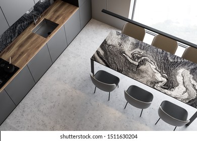 Top View Of Luxury Kitchen With White And Marble Walls, Concrete Floor, Gray Countertops And Cupboards And Marble Dining Table With Gray Chairs. 3d Rendering