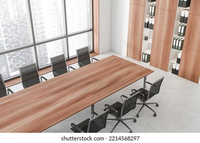 Top View Of Meeting Corner Interior With Armchairs And Long Table. Wooden Shelf With Business Folders On Grey Concrete Floor. Panoramic Window On Singapore City View. 3D Rendering