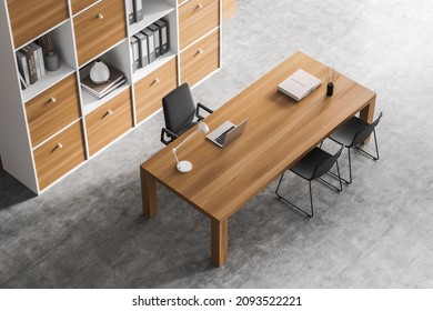 Top view of office interior with chairs and table with laptop, decoration and bookshelf with folders on grey concrete floor. Light consulting room for client service, 3D rendering