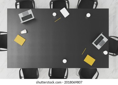 top view of an office table with chairs on the sides and books and laptops on top. 3d render