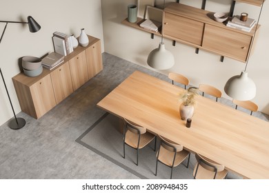 Top view on bright dining room interior with six chairs, table, lamp, shelves, sideboard, carpet and concrete floor. Concept of minimalist design for eating place. 3d rendering