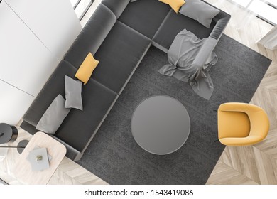 Top View Of Stylish Living Room With White Walls, Wooden Floor, Comfortable Gray Sofa, Yellow Armchair And Round Coffee Table Standing On The Carpet. 3d Rendering