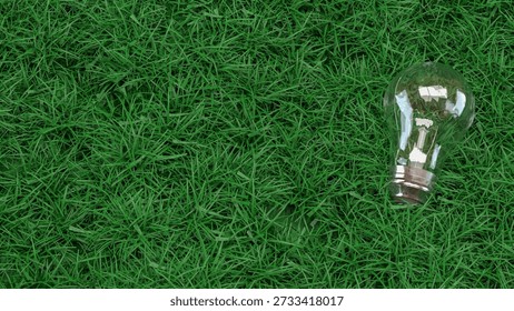 Transparent light bulb lying on fresh green grass symbolizing eco friendly energy sustainability renewable power environmental innovation and clean technology concept