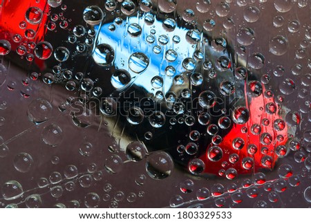 Transparent raindrops flow down on the multi-colored background. Abstract fantasy. 3D render.