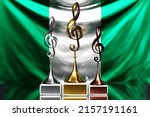 Treble clef awards for winning the music award against the background of the national flag of Nigeria, 3d illustration.