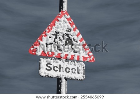 Triangular school road sign covered by snow in storm. 3D illustration of the concept of school closures due to ice and bad weather warning
