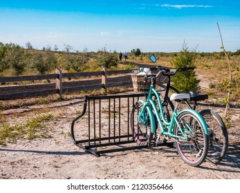 Two Bicycles Parked A Short Distance From A Senior Couple Who Walk Uphill On A Curving Trail In A Nature Preserve On A Sunny Afternoon In Southwest Florida. Digital Oil-painting Effect, 3D Rendering.