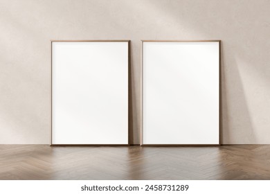 Two empty picture frames leaning against a plain wall on a herringbone parquet floor, awaiting artwork or photographs, 3d render.