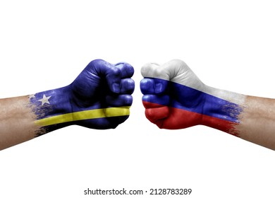 Two hands punch to each others on white background. Country flags painted fists, conflict crisis concept between curacao and russia