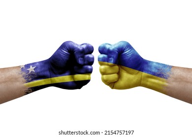 Two hands punch to each others on white background. Country flags painted fists, conflict crisis concept between curacao and ukraine