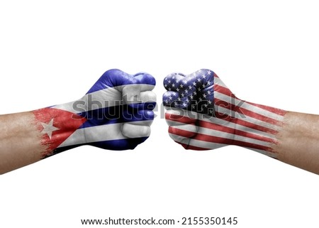 Two hands punch to each others on white background. Country flags painted fists, conflict crisis concept between cuba and usa