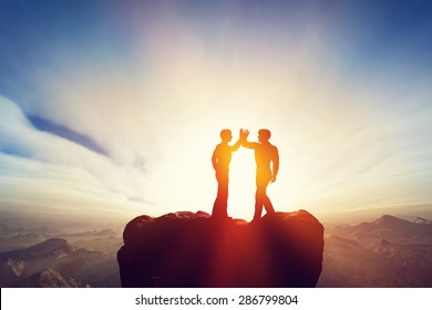 Two Men, Friends High Five On Top Of The Mountains. Agreement, Positive Energy, Friendship Concepts. Sunset Sun Light. 