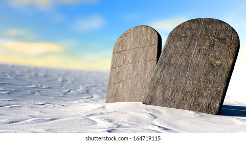 Two stone tablets representing the ten commandments standing in brown desert sand in front of a blue sky