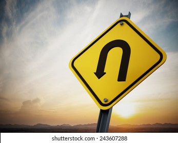 U Turn Road Sign On Setting Sun Background