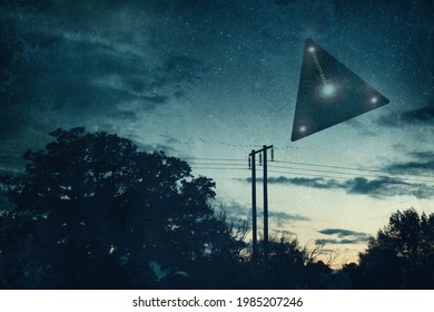 UFO concept. A flying triangle floating above the countryside at night. With a grunge vintage edit 