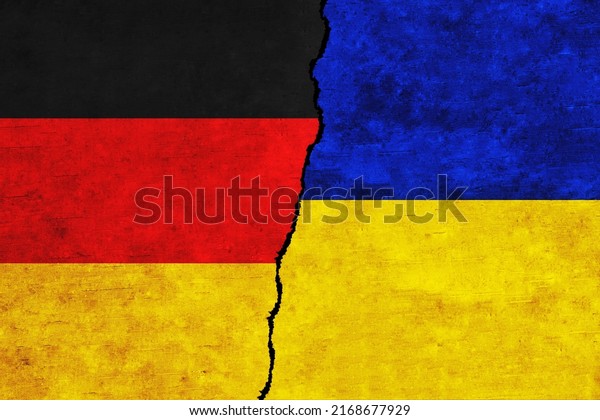 Ukraine and Germany painted flags on a wall with\
a crack. Ukraine and Germany relations. Germany and Ukraine flags\
together