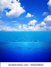 Underwater Scene And Blue Sky With White Clouds. Water Surface Split By Waterline. 3d Render