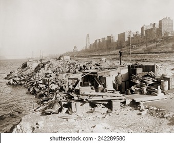 An Unemployed A Man Standing Near His Hut In A New York City Shanty Town During The Great Depression. In The Background Are Upper West Side Landmarks, Grant's Tomb And Riverside Church. 1933.