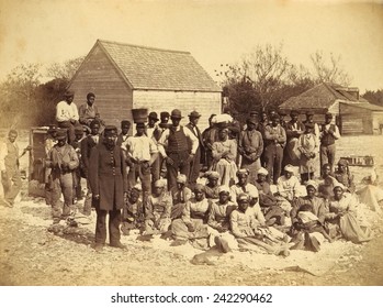 A Union soldier stands with African Americans on the plantation Thomas F. Drayton, Hilton Head Island, South Carolina, 1862. Photo by Henry P. Moore, May 1862.