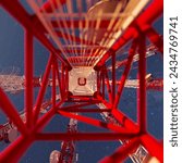 Upward perspective within an imposing telecom tower against a dark, star-filled sky, highlighting its complex metallic infrastructure and essential antennas for communication.