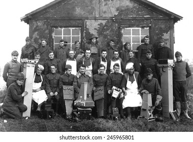 U.S. Army-Air Force 'Balloonatic Section.' Capt. A. W. Stevens (center, front row, with fur collar) and his personnel with the large camera's they used to photograph enemy positions. WWI. Ca. 1918.