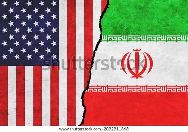 USA and Iran painted flags on a wall with a crack.\
USA and Iran conflict. Iran and United States of America flags\
together. USA vs\
Iran