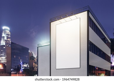 Vertical White Blank Outdoor Billboard With Lighting Backlights On Brick Wall Of Modern Building At Night City Background. 3D Rendering, Mockup