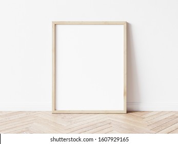Vertical wooden frame mock up. Wooden frame poster on wooden floor with white wall. 3D illustrations.