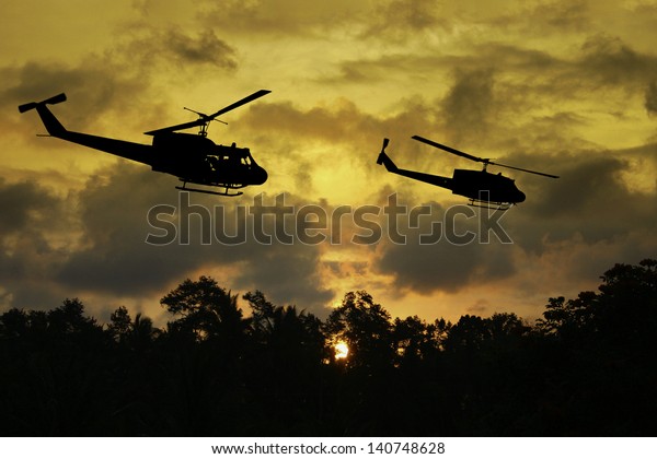 夕暮れ時に 2機のヘリコプターが低空を飛ぶベトナム戦争の スタイル の画像 アーティストの印象 のイラスト素材