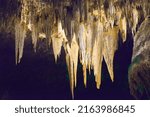 View of Stalactite ceiling in Carlson Bad Cavern.  With yellow, green, and dark purple painted on the formation. 