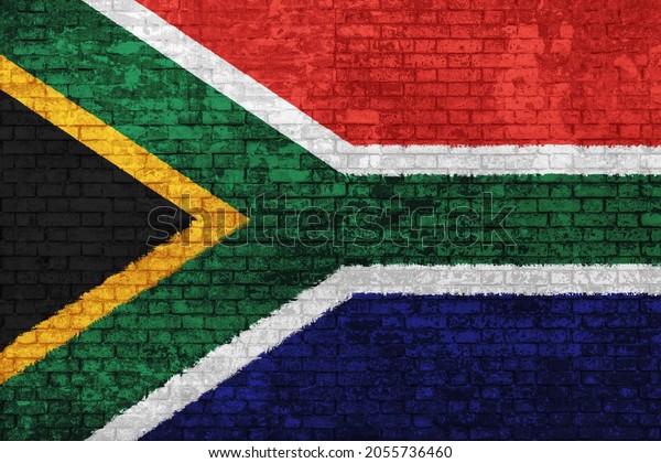 Wall of bricks painted with flag of South Africa,\
blue red black, white and yellow colors. 3D background. Concept of\
social barriers of immigration, divisions, and political conflicts\
in South Africa