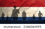 War in Nederland, shadow of soldiers in the battlefield on dirty flag Nederland, war crisis concept in Nederland