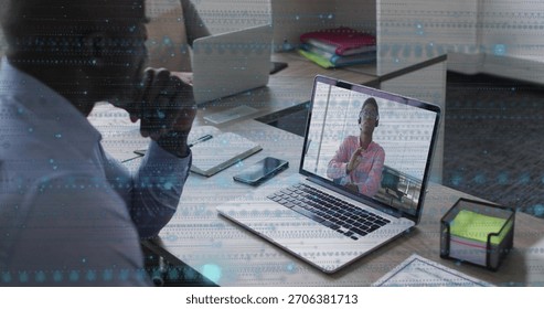 Watching man in light top checking laptop, remote woman in pink gesturing, neon notes phone office. Desk, meeting, collaboration, screen, modern, moody, workspace