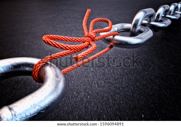 Weakest link, security break fix and\
strength concept, metallic chain connected by a red knotted rope on\
black background, 3d\
illustration