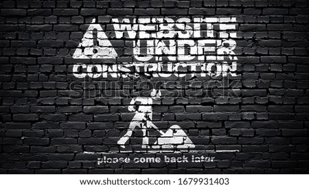 Website graphic, page under construction, white text on black brick wall