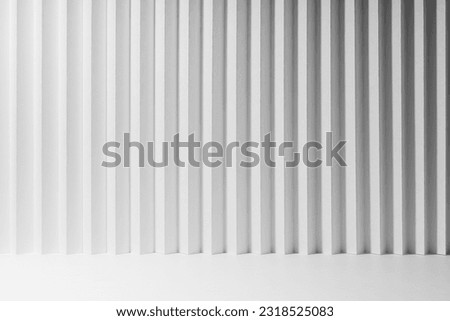 White abstract background of vertical folded striped gradient pattern, perspective, floor as stage mockup for presentation cosmetic products, goods, advertising, design, soft light modern urban style.