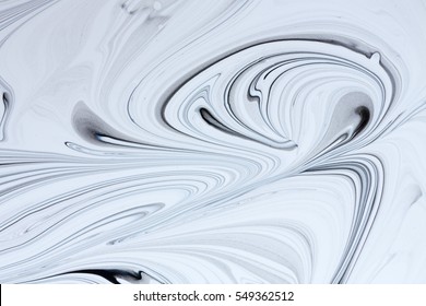 White And Black Paint Mixing Together Creating Shapes.