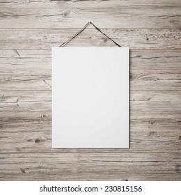 White Blank Poster Hanging On Leather Belt On Wood Background