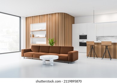 White kitchen interior with sofa, two bar chairs and coffee table on light concrete floor, side view, panoramic window with countryside. Wooden wall with rack and decoration, 3D rendering