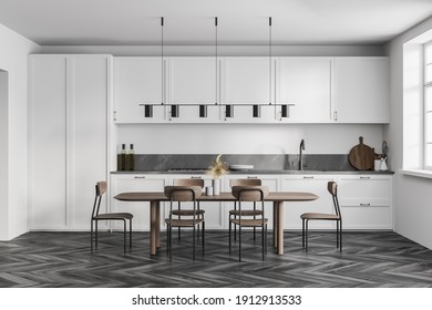 White Kitchen Room With Kitchen Set On Black Parquet Floor. Eating Table With Wooden Chairs Near Window, 3D Rendering No People