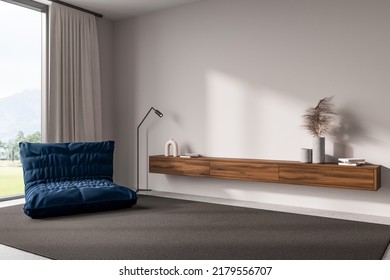 White Living Room Interior With Pouf Chair, Side View, Carpet On Grey Concrete Floor. Floating Drawer With Art Decoration, Panoramic Window On Countryside. Mockup Copy Space Wall. 3D Rendering